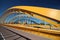 Bright yellow bridge named Hogeweidebrug over the Amsterdam-Rhine canal in Utrecht for traffic and Vleutenspoorbrug which is a tra