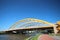 Bright yellow bridge named Hogeweidebrug over the Amsterdam-Rhine canal in Utrecht for traffic and Vleutenspoorbrug which is a tra