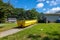 A bright yellow dumpster in the driveway of a home in a residential neighborhood