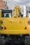 Bright Yellow Excavator Behind Empty Mockup Advertising Space Construction Roadwork Vehicle Close Up