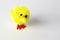 Bright yellow fluffy toy chicken used as easter decoration, placed on white table looking upwards
