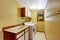 Bright yellow laundry room with cabinets and sink