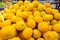 Bright yellow lemon pile at farmer`s market or grocery store. Front view