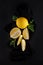 Bright yellow lemons, slices, rustic food photography on dark slate plate kitchen table