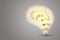 Bright yellow light bulb in brain shape with grey background.
