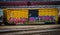 Bright yellow railroad car tagged with graffiti