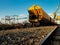 Bright yellow railway freight car against the blue sky in the port of Strasbourg