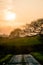 The bright yellow sun setting over a farm