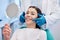 The brightest smile in the room. Shot of a young woman checking her results in the dentists office.