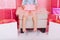 Brightful stylish image birthday present on knees of little cute girl in tulle skirt sitting on chair suround a lot of