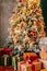 Brightly christmas tree in a room with red carpet with lots of gifts under it. New year holidays