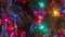 Brightly colored, cheery Christmas tree ornaments hung up with lights and tinsel