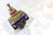 Brightly colored cloisonne Hanukkah dreidel on a soft white background