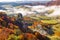 Brightly colored forests of mountain valley in the morning mist