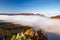 Brightly colored forests of mountain valley in the morning mist