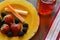 Brightly colored plate with fruit, sausage and cheese on wood background