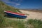 Brightly coloured boat on the beach at Beadnell Bay