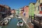 Brightly coloured/colored houses, by a canal, on Burano Island, Venice, Italy
