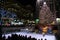 A brightly illuminated Rockefeller Plaza with a Christmas tree