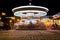 Brightly illuminated traditional carousel at night city festival