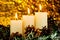 Brightly lit Christmas candles, snow-covered spruce Winter branch and cones. Candle light is a symbol of faith, hope, love,