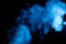 Brightly Lit Plume of Blue Smoke Over a Black Backgound