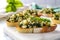 brightly lit shot of spinach and artichoke bruschetta on a cool marble countertop