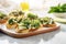 brightly lit shot of spinach and artichoke bruschetta on a cool marble countertop