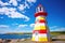brightly painted lighthouse under sunny skies