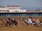 Brighton Pier with people relaxing on the beach