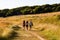 Brighton, UK - June 2018 Three Girls Walking on Greenfield Pathway on Sunny Day. People Passing through Grassy Footpath