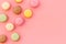 Brignt macarons for sweet break on pink background top view mock up