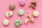 Brignt macarons for sweet break on pink background top view pattern