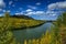 Brilliant autumn colors line the powerful Liard River