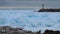 Brilliant blue coloured ice in the harbour on a cloudy winter day