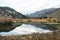 BRilliant fall colors light up the edge of an alpine lake