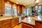 Brilliant kitchen with stained wood cabinets and hardwood floor.