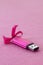 Brilliant pink usb flash memory card with a pink bow lies on a blanket of soft and furry light pink fleece fabric. Classic female