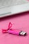 Brilliant pink usb flash memory card with a pink bow lies on a blanket of soft and furry light pink fleece fabric beside to a whi