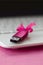 Brilliant pink usb flash memory card with a pink bow lies on a blanket of soft and furry light pink fleece fabric beside to a whi