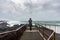 Brimketill lava rock pool in Iceland silhouette of person in front of stormy ocean