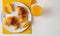 Brioche croissants on a plate with orange juice flat lay