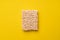 Briquette of instant dry egg noodles on yellow background