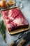 Brisket flat cut, raw beef brisket meat,with ingredients for smoking  making  barbecue, pastrami, cure, on gray stone background