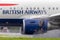 British Airways Airbus A318-112 aircraft G-EUNB landing on the wet runway with reverse thrust spraying water