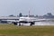 British Airways Airbus A318-112 aircraft G-EUNB landing on the wet runway with reverse thrust spraying water