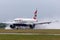 British Airways Airbus A318-112 aircraft G-EUNB landing on the wet runway with reverse thrust spraying water