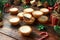 British Christmas iced mince pies with decoration, gifts, green tree branch on wooden rustic table