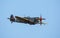 A British Spitfire fighter flying against a bright blue sky