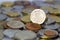 British twenty pence coin on top of a large pile of coins